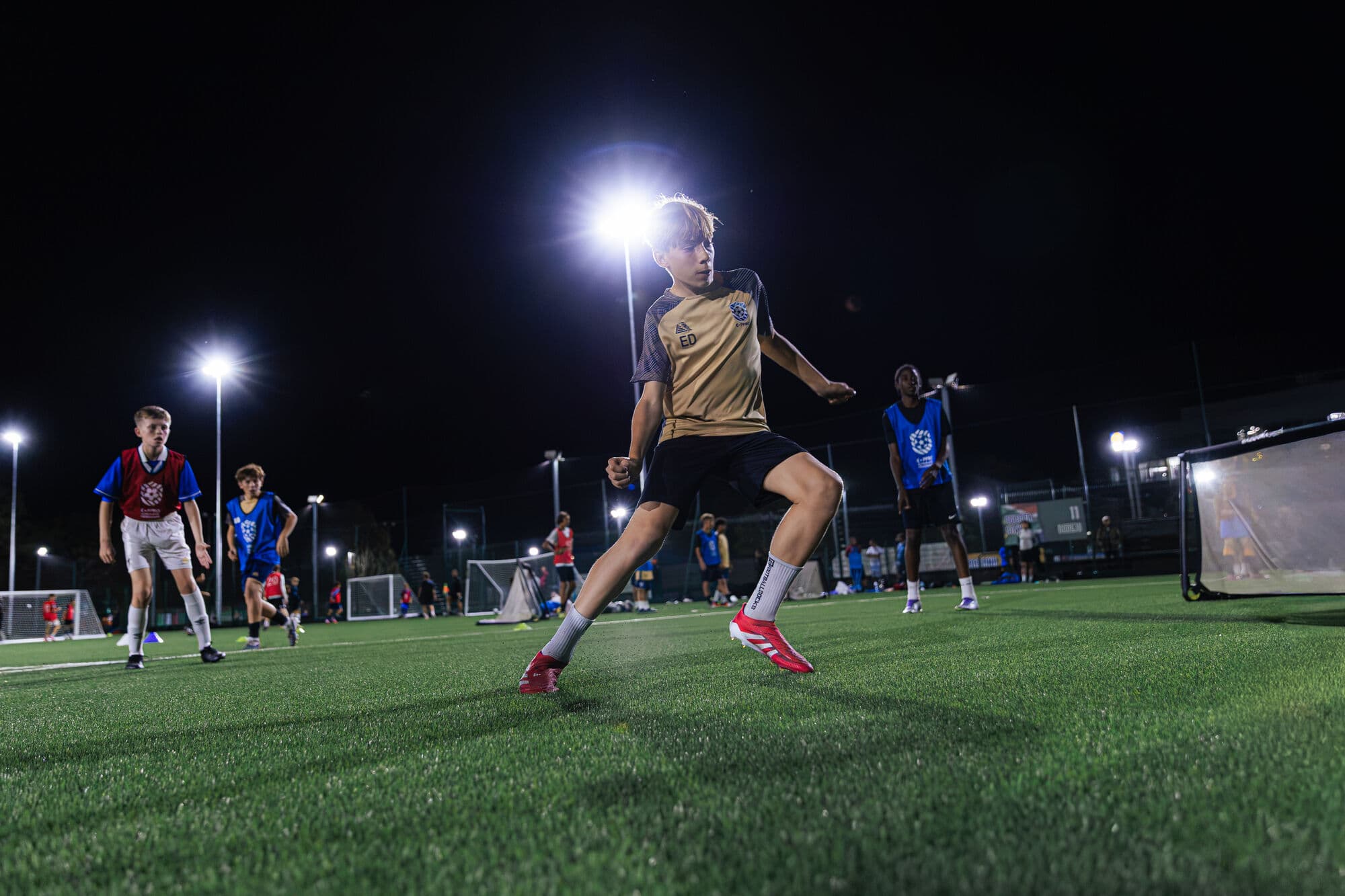 An E-PPRO player striking the ball under floodlights