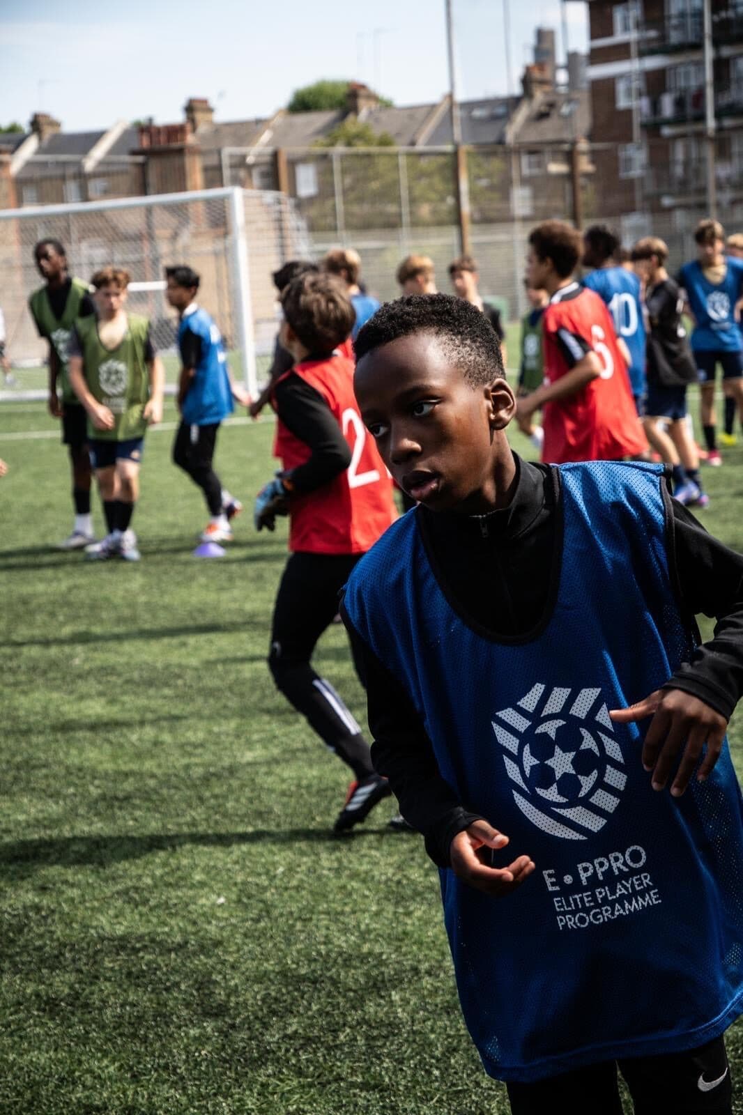 Players warming up in E-PPRO bibs across the Westway pitch