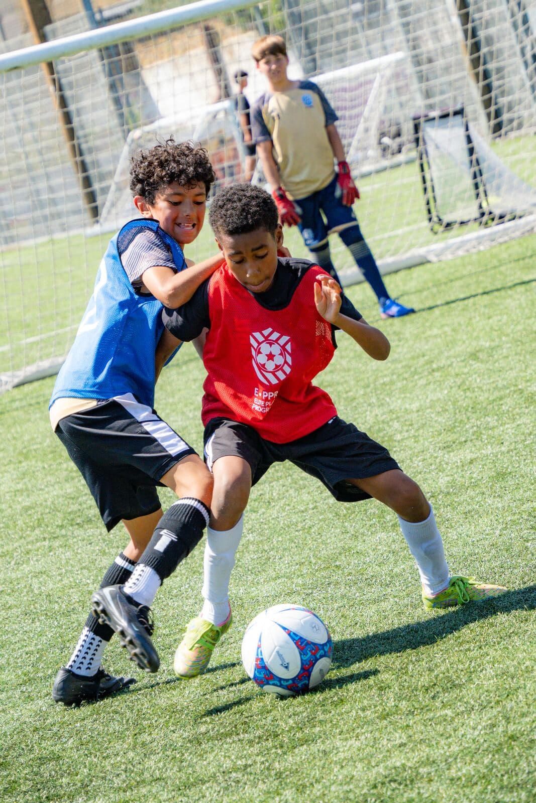 Two players competing for the ball at Westway